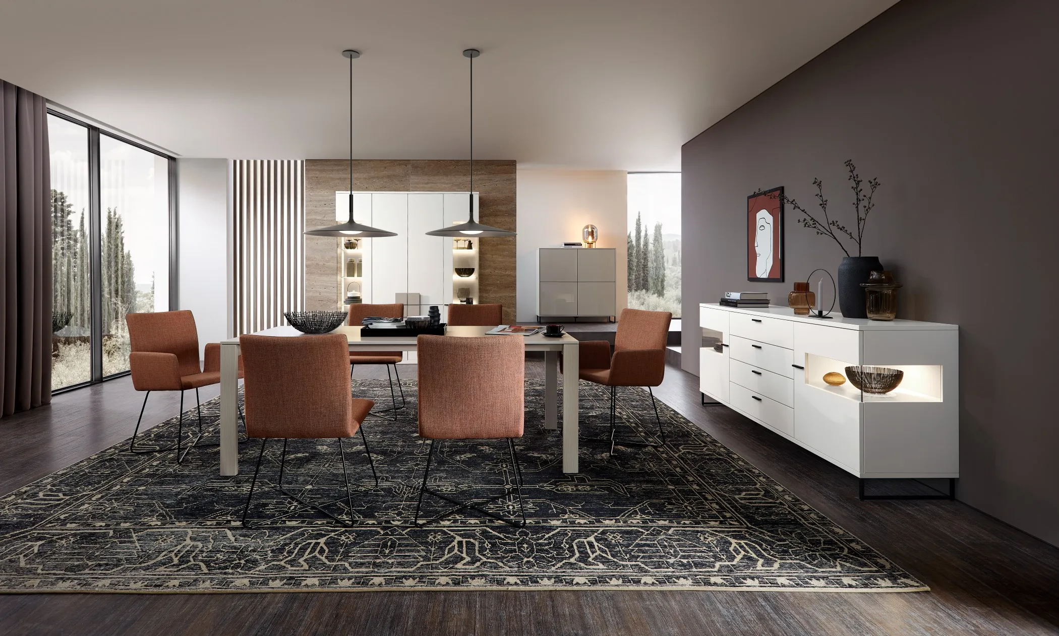 Sie sehen ein Esszimmer mit Sidboard in Weiß hochglanz mit Glas und Beleuchtung. Ein Highboard dazu. Ein Schlammfarbenes Sideboard ergänzt das Ensemble. Im Vordergrund ist eine Essgruppe zusehen, mit roten Stühlen.